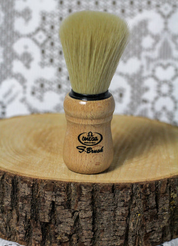A soft bristled shave brush sitting on a wooden round